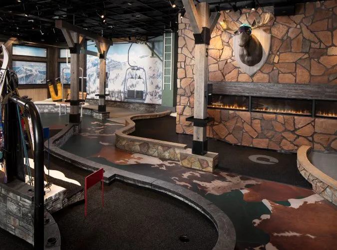 Cozy ski lodge themed mini-golf course at The Lodge with winter decorations.