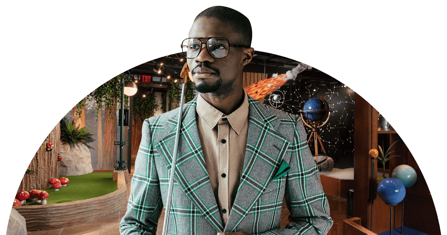 Elegant man in suit, confidently holding a golf putter on his shoulder, stands before the sophisticated backdrops of the Puttery Library Course.